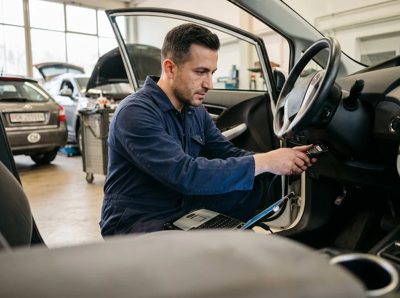 Automobilmechatroniker bei der Arbeit in Schweizer Autowerkstatt